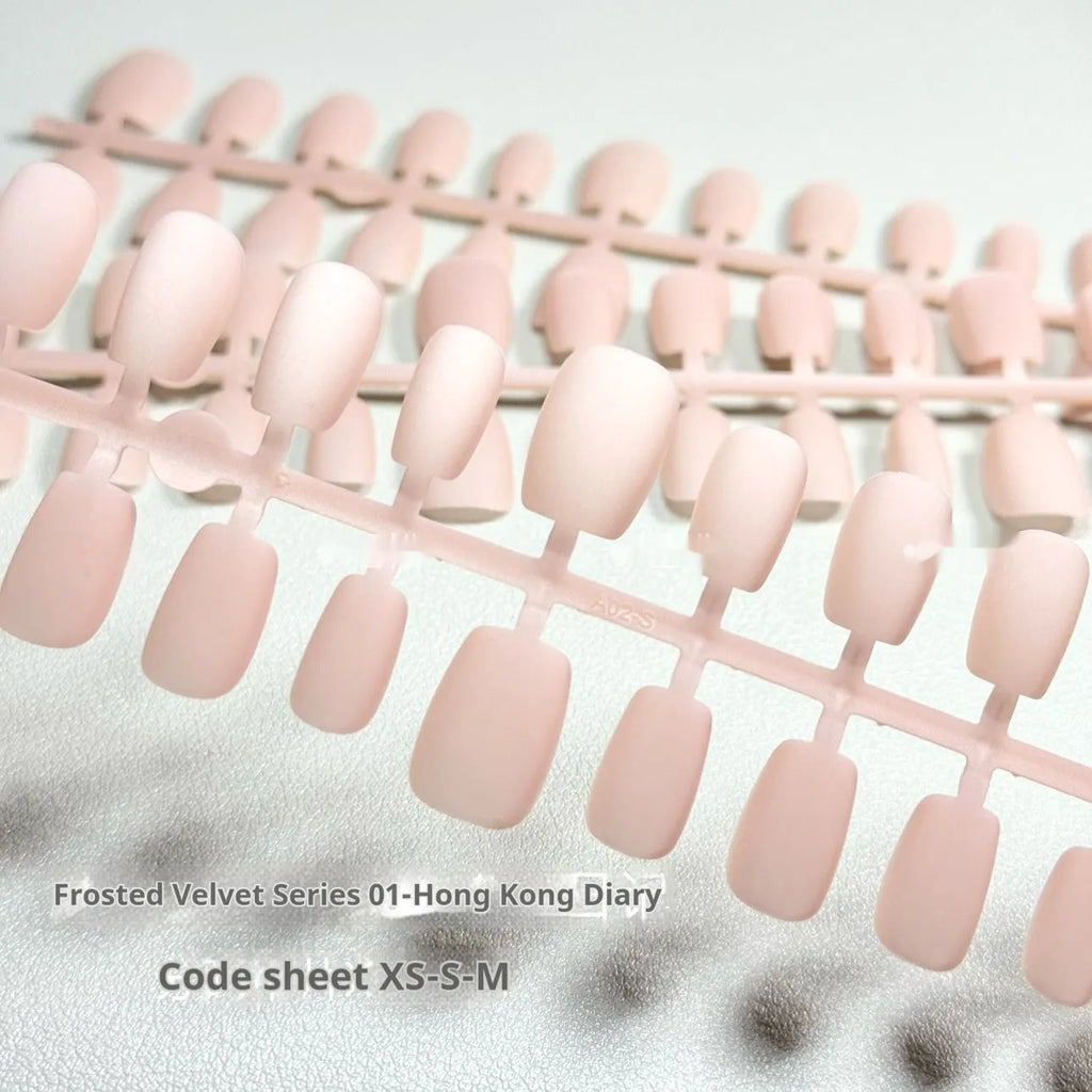 Set of frosted velvet Cat's Eye false nails in short ladder sizes XS, S, and M on a display stand.
