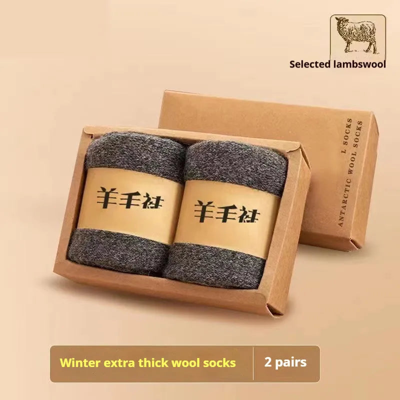 Two pairs of thick grey and black merino winter ankle socks with a thick midsole on a presentation box.