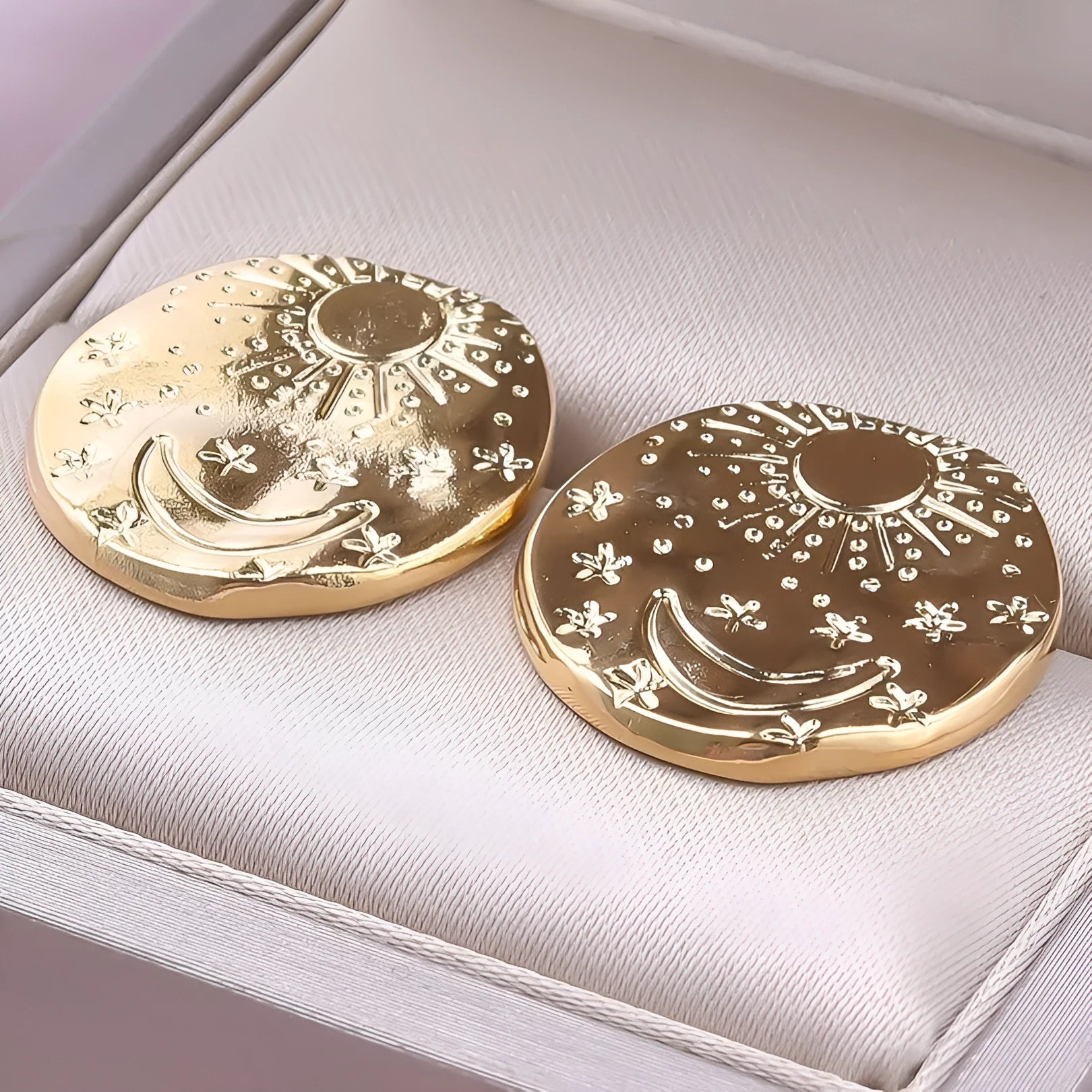 A pair of geometric shell design stud earrings in 304 stainless steel with a gold electroplated finish.