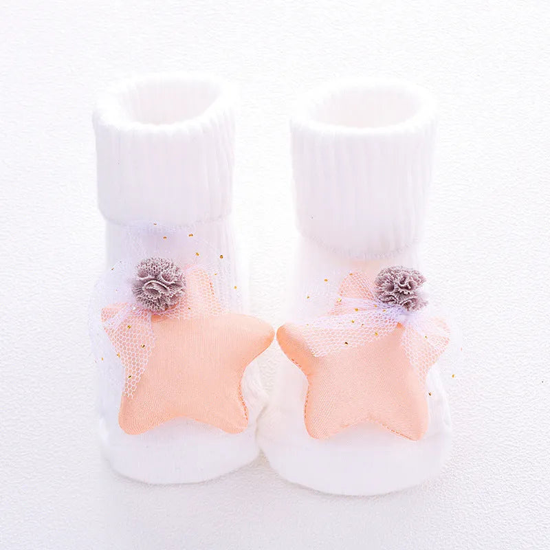 Cotton baby floor socks in a pink bow pattern, shown on an infant's feet.