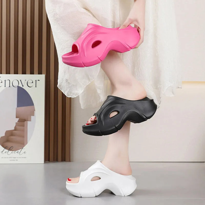 Women's white thick-sole EVA beach slippers with a round toe, shown on a sandy background.