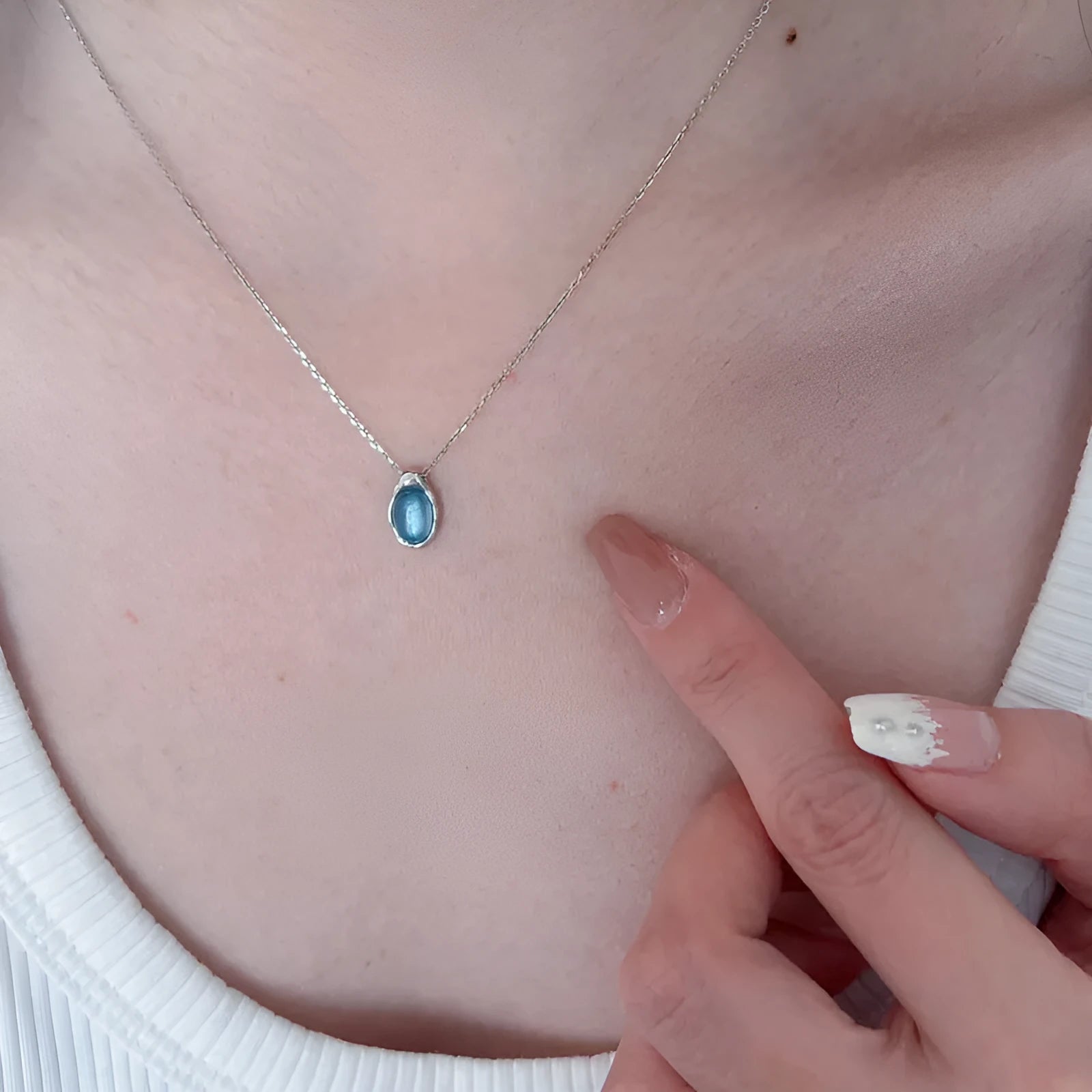 Geometric navy blue water drop pendant on an adjustable platinum-colour cross chain necklace.