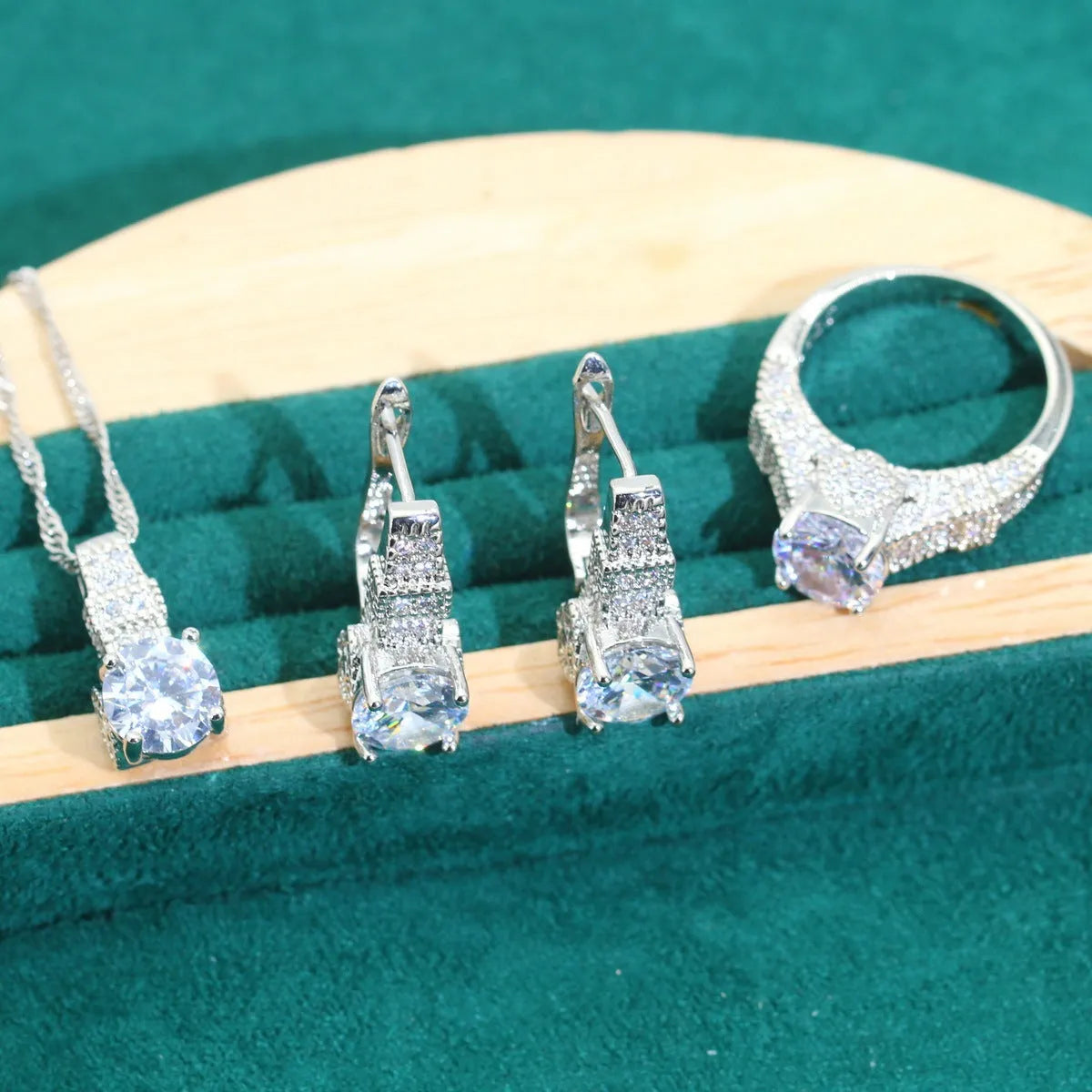 Four-piece bridal zircon jewellery set showing necklace, bracelet, earrings, and ring in a choice of colours.