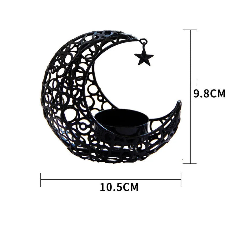 Gold metal crescent moon candle holder with hollow design on a dark surface