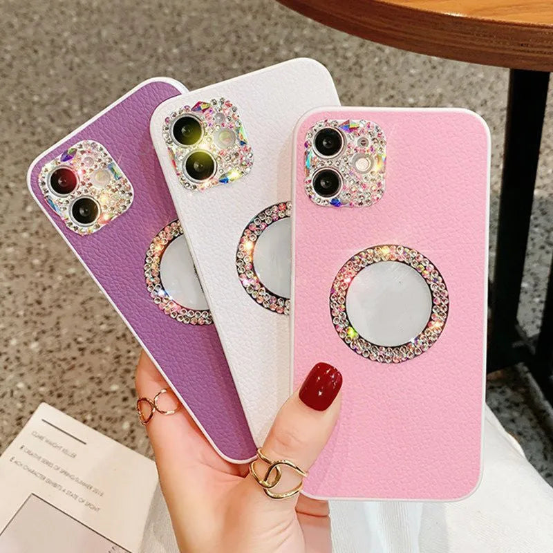 Luxury rhinestone TPU back cover phone case for iPhone in pink, purple, and white on a surface
