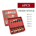 Red stainless steel Christmas spoons and forks with snowman, tree, and Santa handle designs.