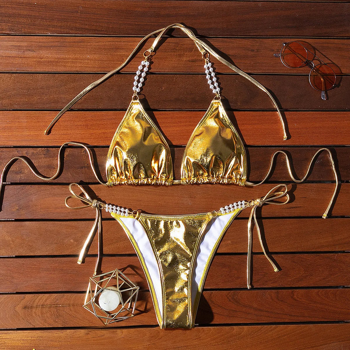 Gold halter neck bikini top with lace-up front and matching briefs, featuring pearl chain detail.