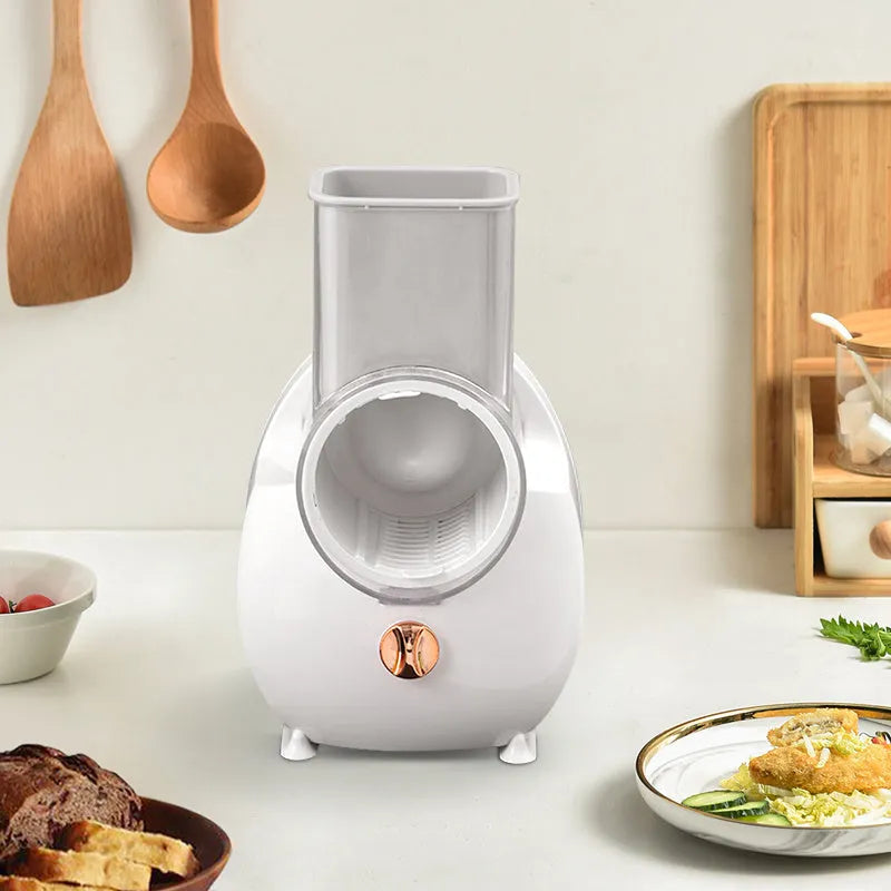 White electric vegetable slicer with rotary grater, suction base, and multiple blades on kitchen counter