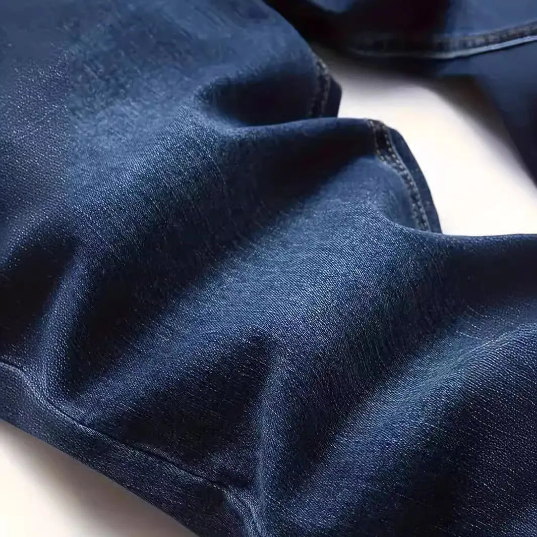 Man wearing dark blue slim-fit skinny jeans with a mid waist and zip fly.