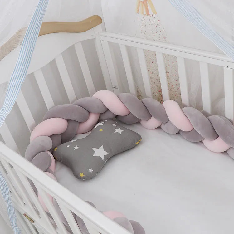 Bendable braid knot baby crib bumper in spandex velvet fabric on a white cot.