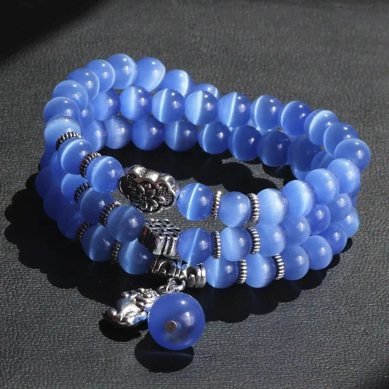 Women's opal bracelet with a Cat Eye charm, shown in one of six colours, wound three times around a wrist.