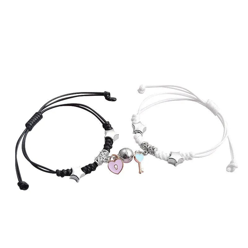 A pair of magnetic couple bracelets with alloy charms showing an I love you design and a key lock on a textured background.
