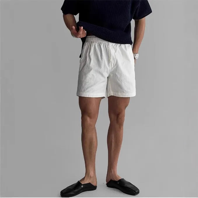 Man wearing black loose-fit cotton sports shorts for summer activity.