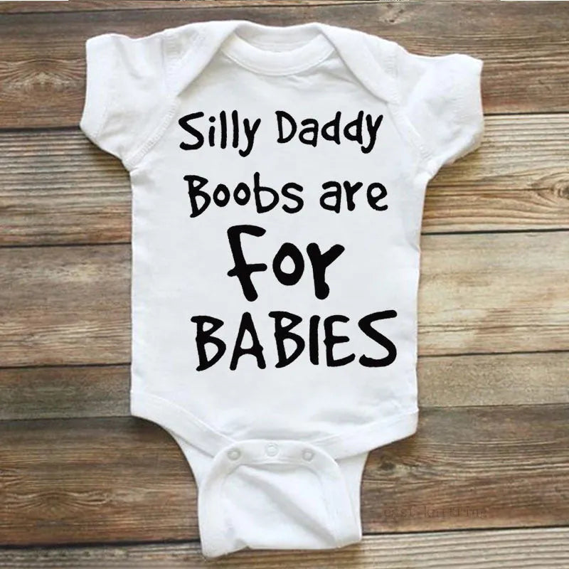 White triangle climbing baby bodysuit with black text reading 'Silly Daddy Boobs Are For Babies'