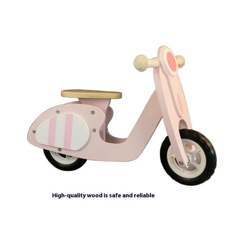 A pink wooden balance scooter for toddlers and children with a 10-inch deck.