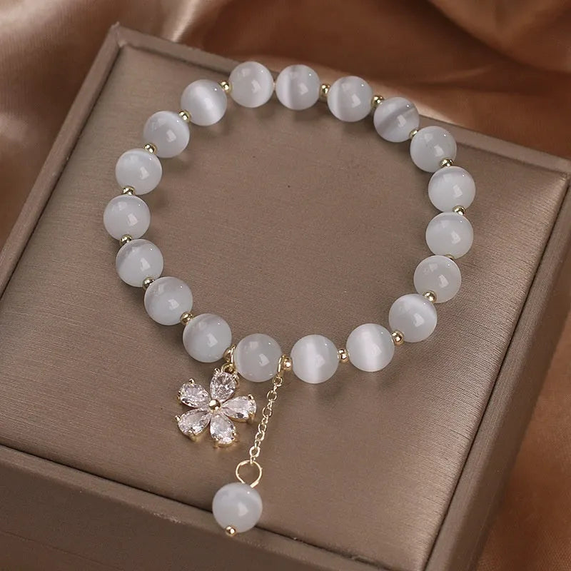 Women's white cat's eye crystal bracelet with flower tassel and morganite safety buckle.