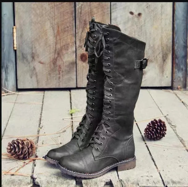 Women's black chunky heel high-leg boots with a round toe and low rubber sole.