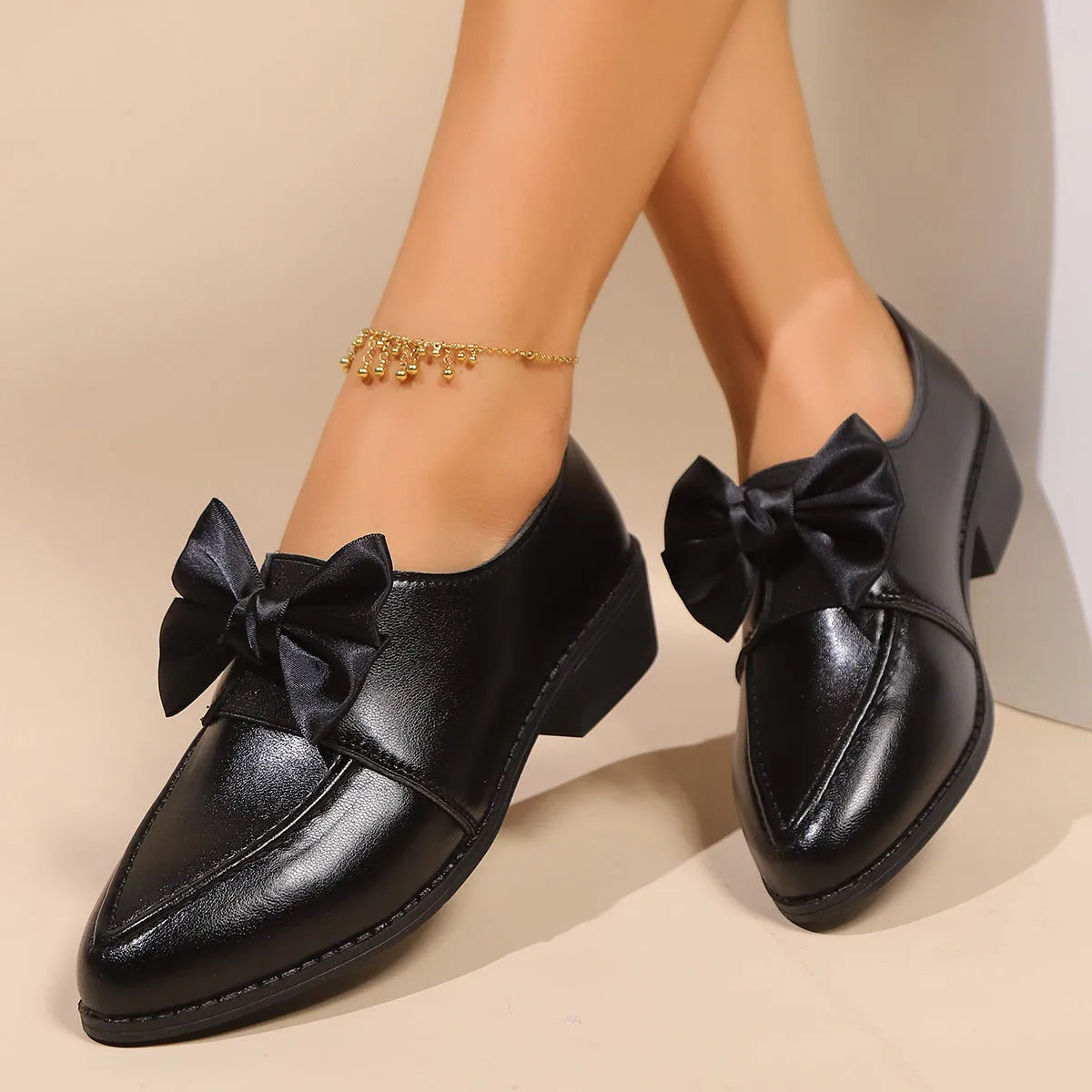 Women's simple leather-look flat shoes with a decorative bow, shown in slip-on style with a rubber sole.
