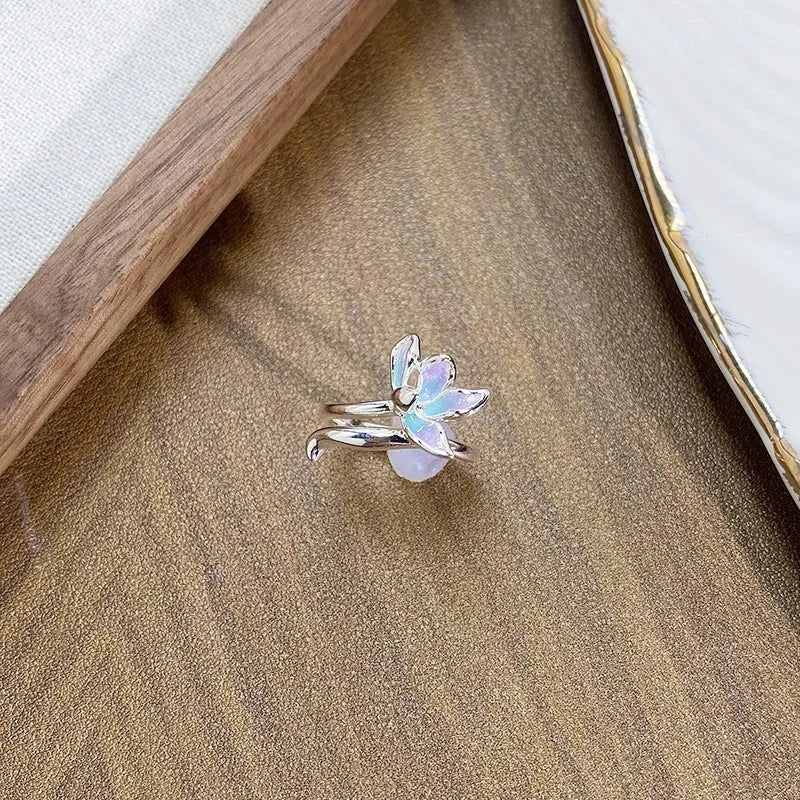 Close-up of an adjustable, irregularly shaped copper ring featuring a detailed insect motif.