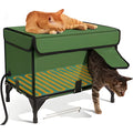 Green foldable cat cage with removable cloth cover, shown in a garden setting.