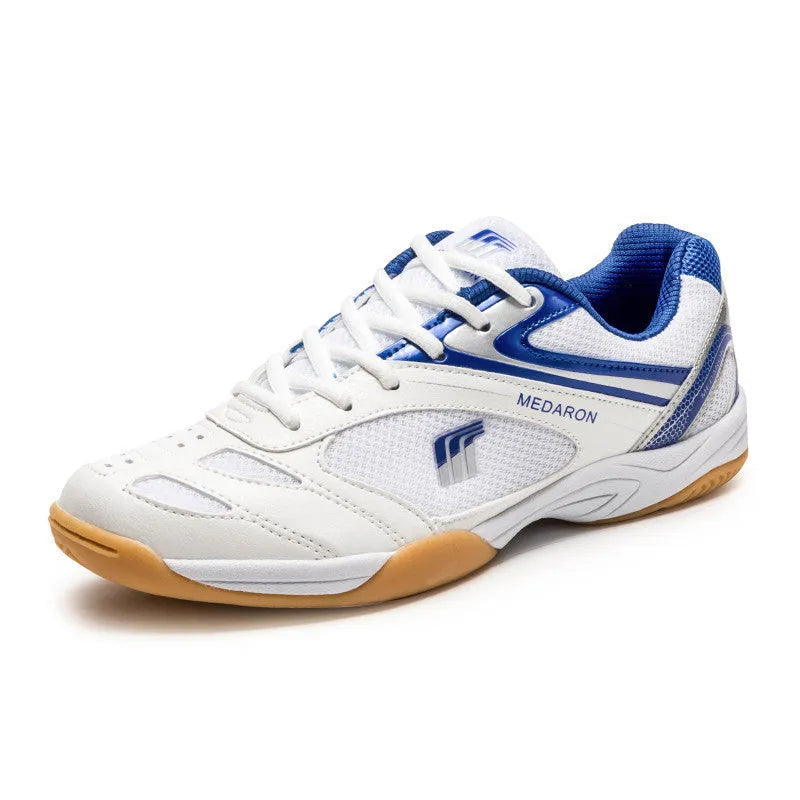 White and blue table tennis shoes with mesh panels and rubber sole on a court surface.