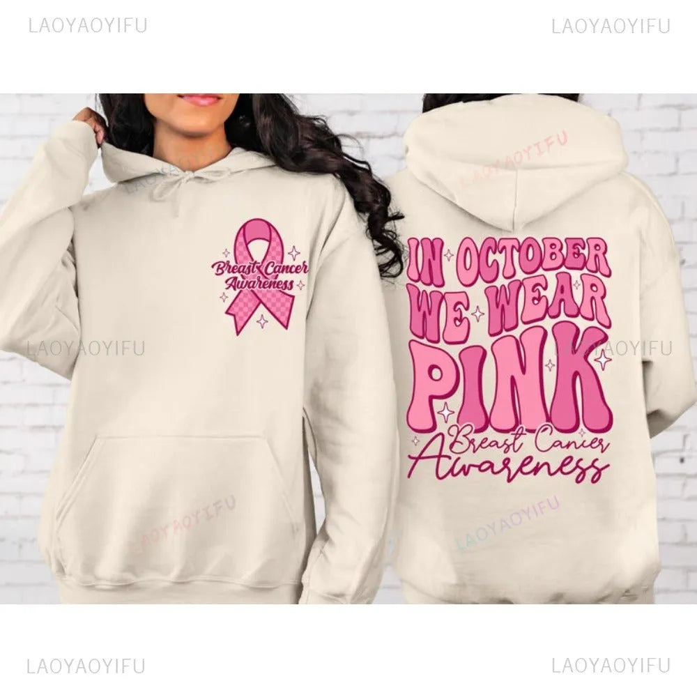 Pink breast cancer awareness hoodie with retro pattern and side pocket on a hanger.