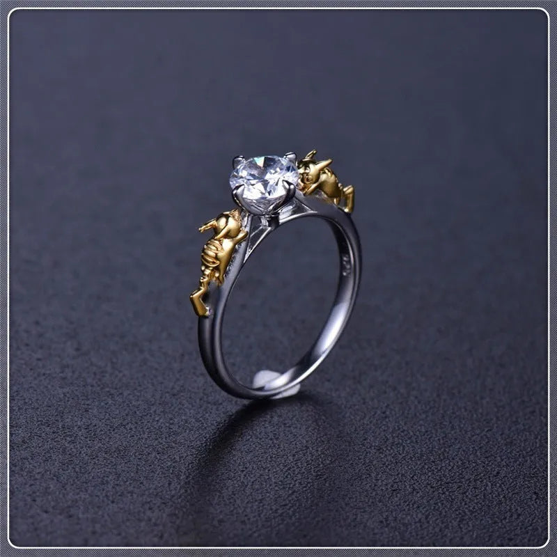 Copper crown-shaped crystal ring in a black gold tone on a neutral background.