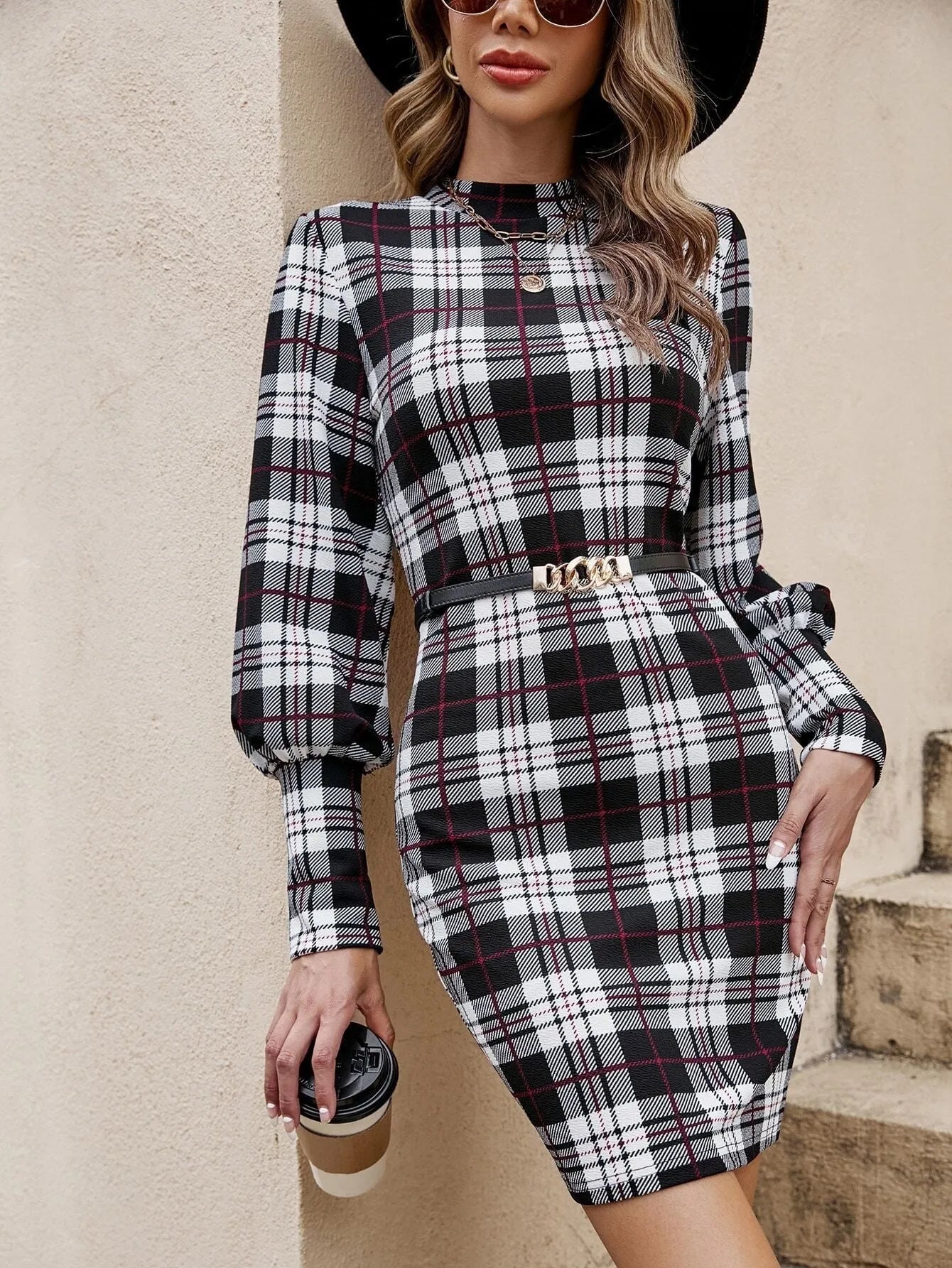 Black tight-fitting dress with voluminous lantern sleeves and decorative leather stitching.