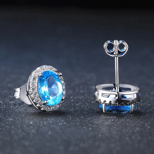 925 sterling silver four-piece jewellery set with blue topaz gems showing geometric-designed earrings, ring, pendant, and necklace