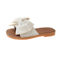Women's beige suede sandals with bow detail and flat rubber soles