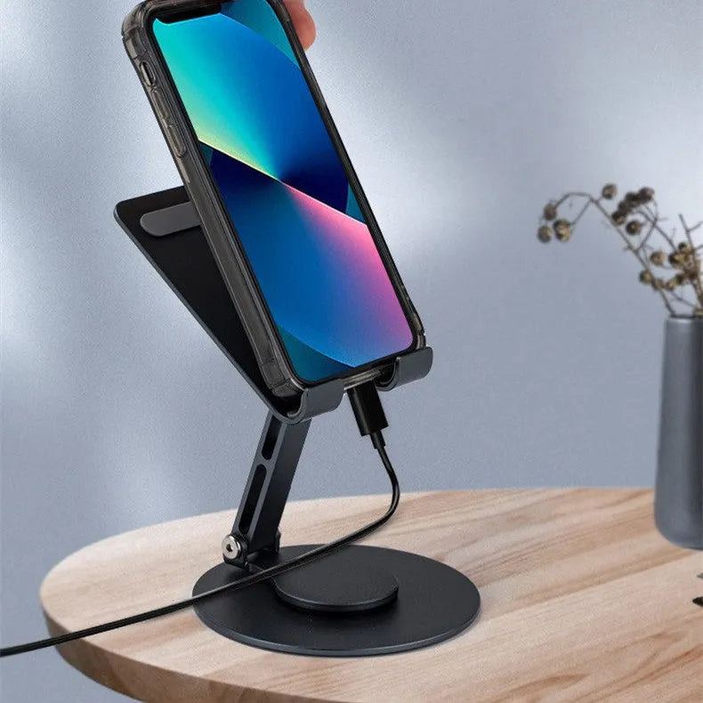 Grey aluminium alloy rotating mobile phone bracket on desk with silica gel grip, 4.8 x 4.2 x 1.4 cm, holding a smartphone in landscape mode