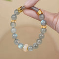 Grey moonstone agate half-wrap bracelet with 8mm round beads on a woman's wrist.