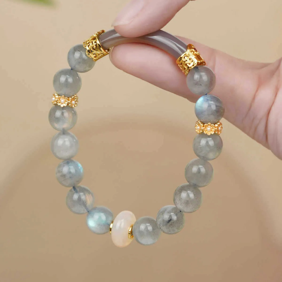 Grey moonstone agate half-wrap bracelet with 8mm round beads on a woman's wrist.