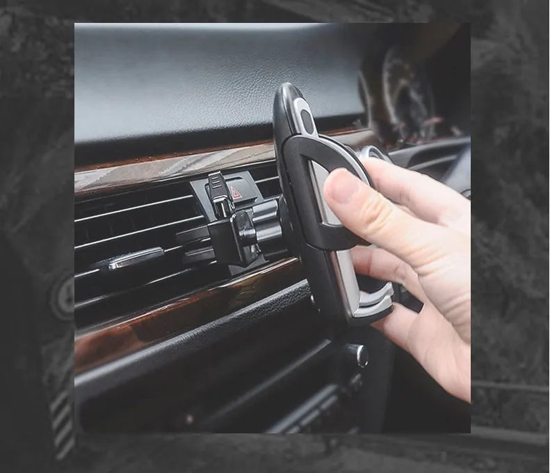 Black plastic car phone holder mounted on air conditioning vent holding smartphone