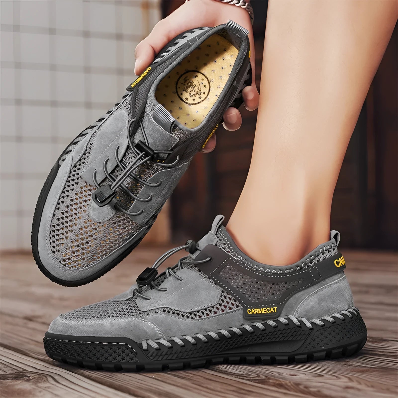 Men's grey suede low-top trainers with elastic band and hand-stitched rubber sole.