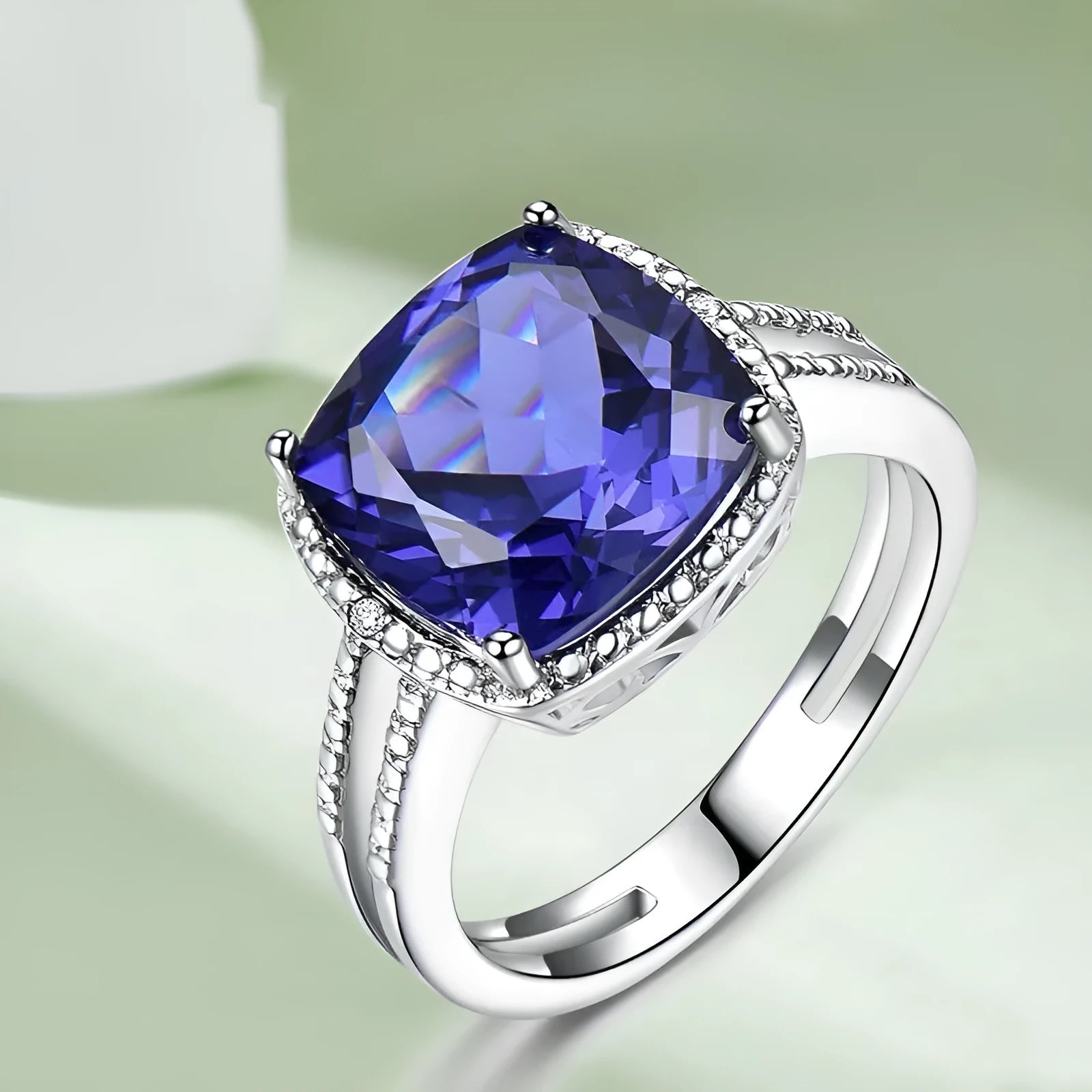 Blue Tanzanite stone set in a sterling silver women's ring on a plain background.