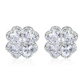 Close-up of a pair of heart-shaped 925 silver earrings with a four-leaf clover charm and zircon stones, in white gold colour.