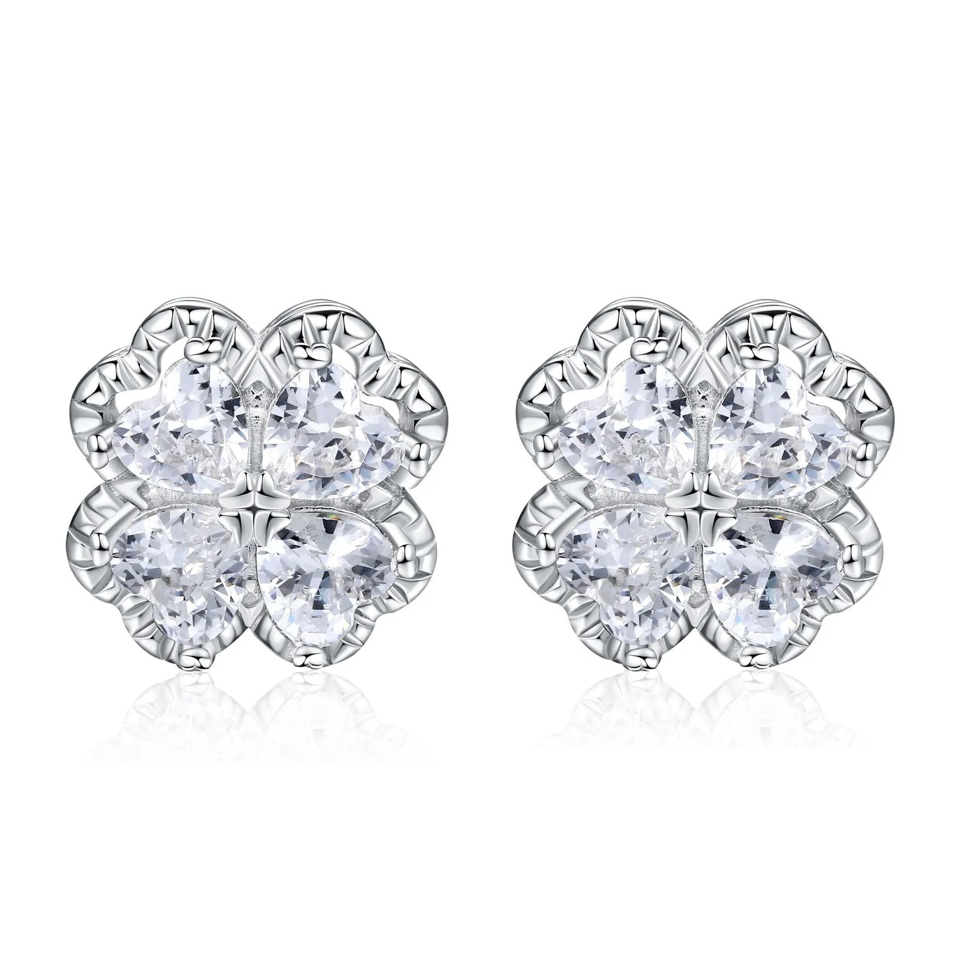 Close-up of a pair of heart-shaped 925 silver earrings with a four-leaf clover charm and zircon stones, in white gold colour.