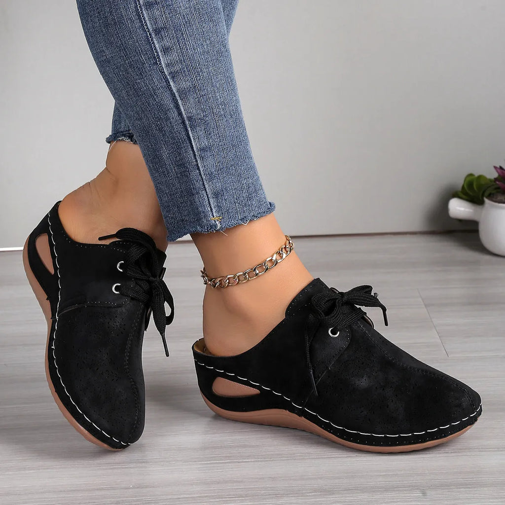 Women's black lace-up wedge slippers with hollow-out design, suede upper, and rubber sole.