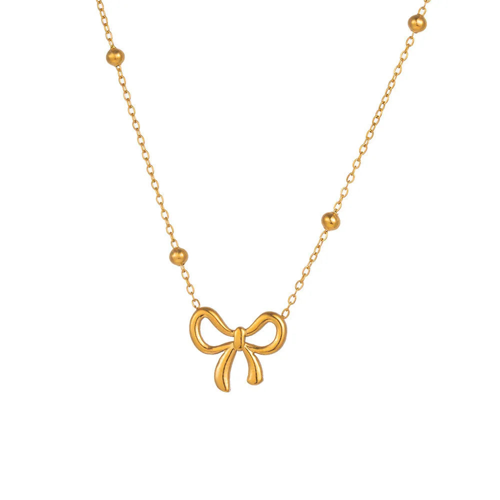 Gold bow necklace on a cross chain, adjustable from 41cm to 50cm length.