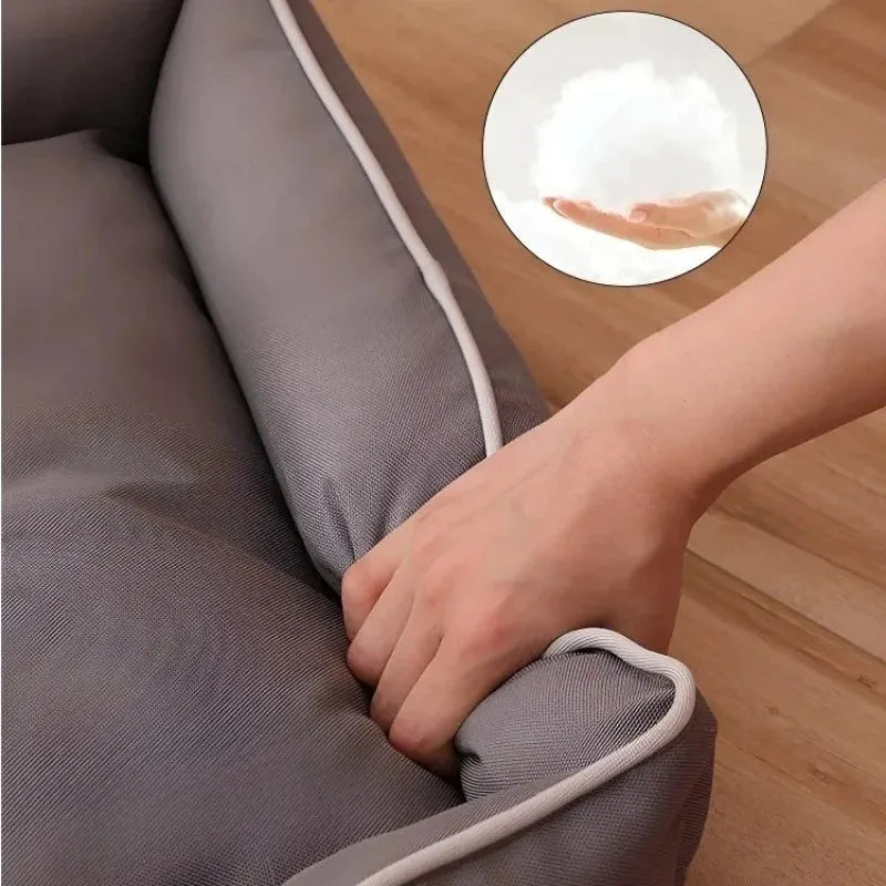 Grey waterproof dog sofa bed with padded sides on a wooden floor