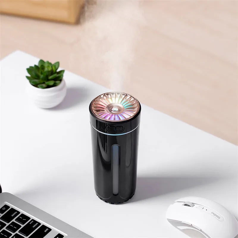 Black portable USB humidifier with colourful lights on a car cup holder.