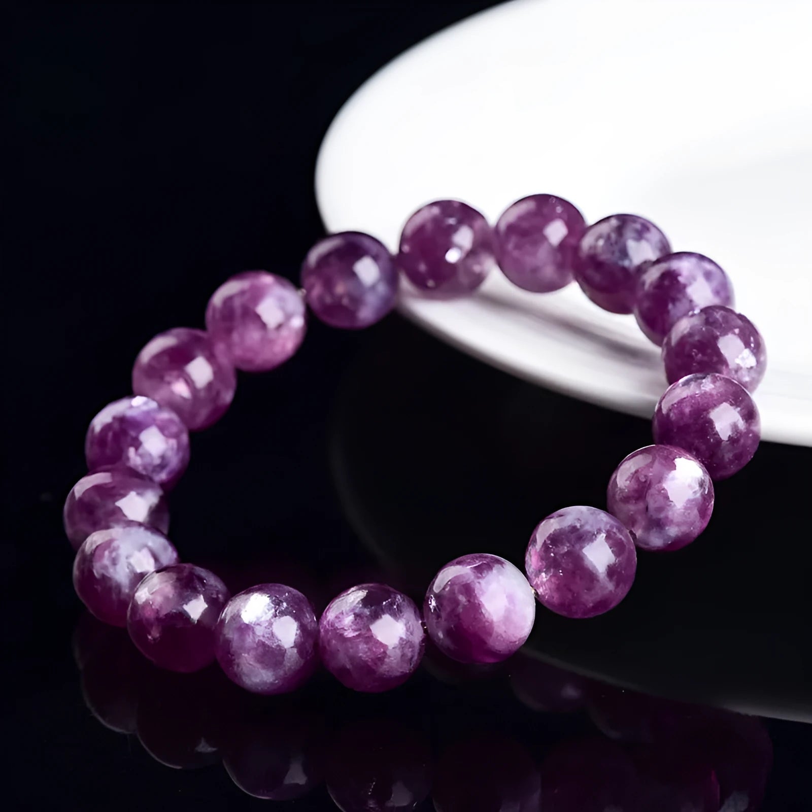 Polished purple crystal bracelet with geometric beads on a white background.
