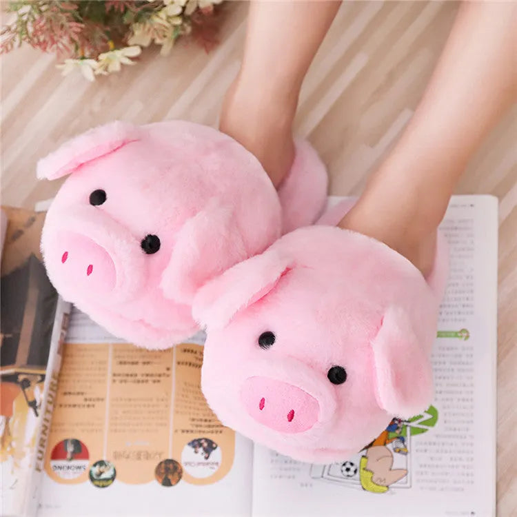 Pink pig-shaped plush floor slippers with soft filling on a plain background.