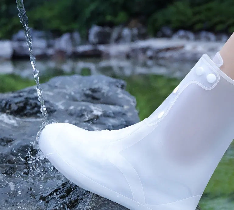 White PVC high-top reusable shoe covers for women, shown on feet.