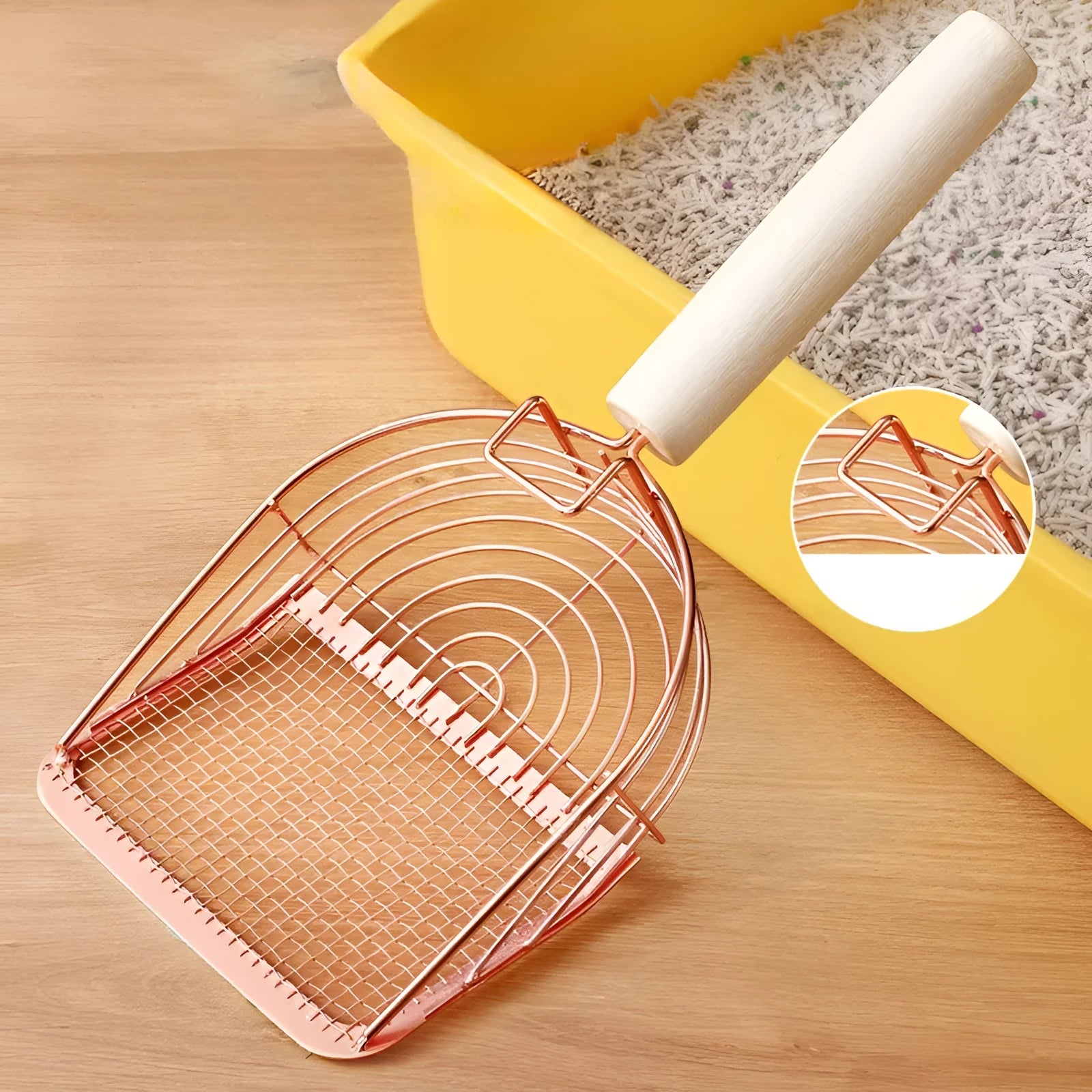 Stainless steel cat litter scoop with a wooden handle for cleaning the litter box.