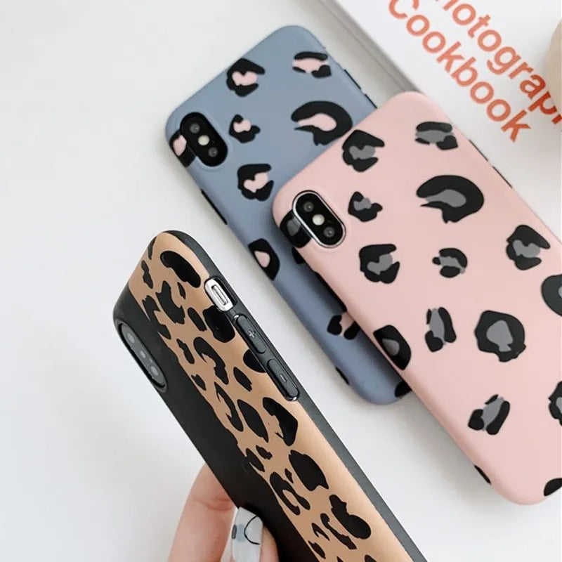 Leopard print pattern phone case for iPhone models on a table.