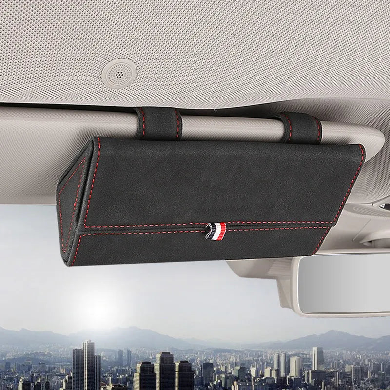 Suede car glasses storage box in beige attached to car sun visor holding sunglasses and phone