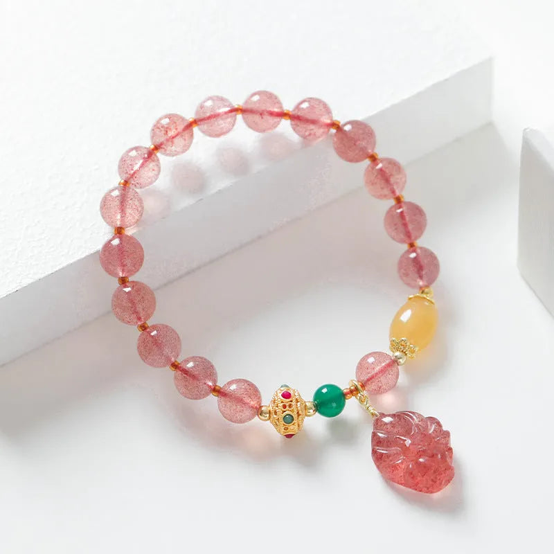 Women's crystal beaded bracelet with a strawberry quartz nine tail fox charm on a white background.