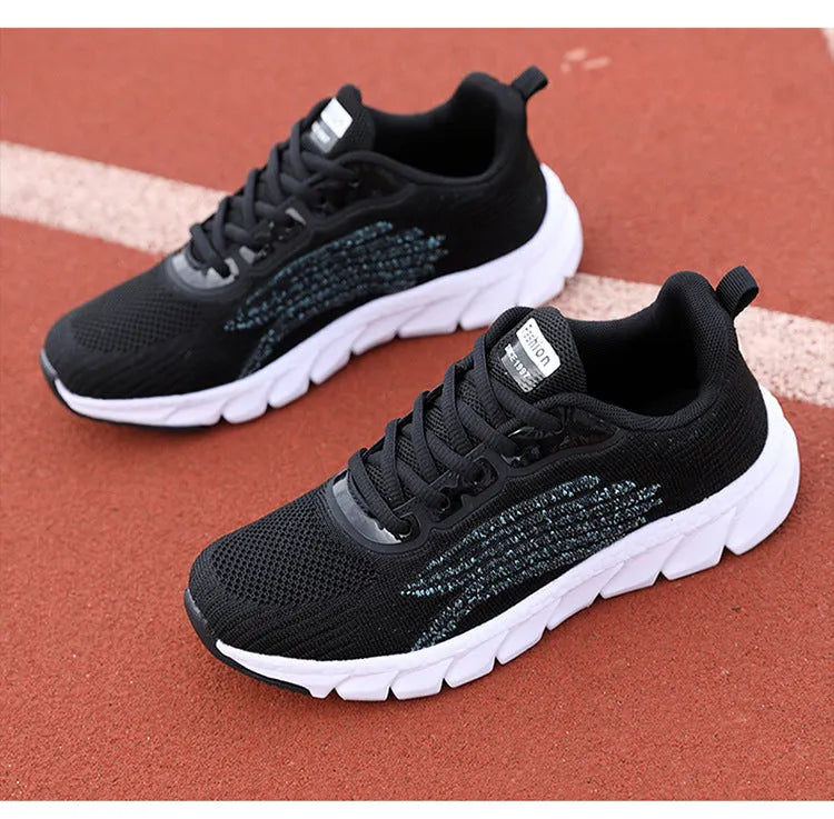 Flat running sneakers with cross-strap detail in black or white colours